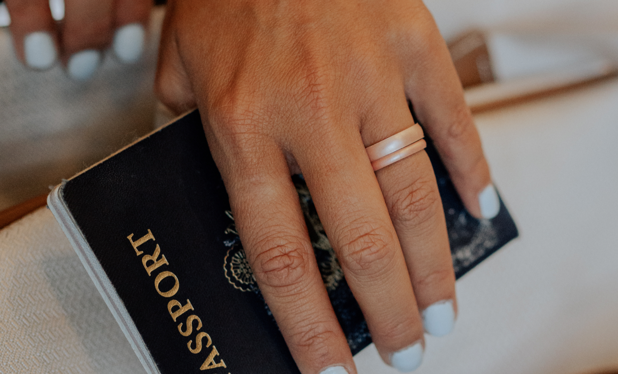 Hand with legend rings holding a passport